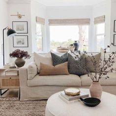 a living room filled with lots of furniture next to a white couch and coffee table