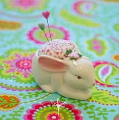 an elephant figurine with a flower in its trunk on a colorful tablecloth