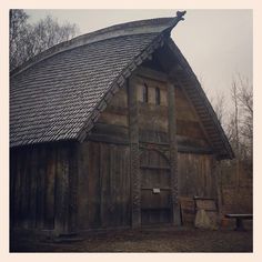 an old wooden building with a roof made out of wood planks and shingles