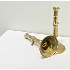 an antique brass trumpet on a white surface