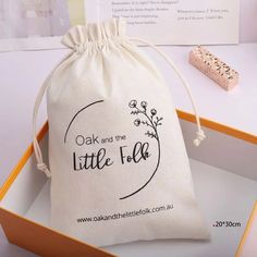 a white bag with the words oak and the little folk printed on it