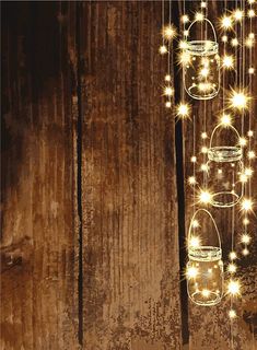 three mason jars with lights hanging from them