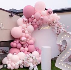 a large balloon arch with flowers and balloons