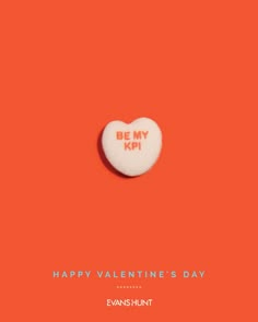 a heart shaped candy with the words happy valentine's day written in red on an orange background