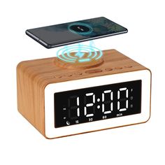 an alarm clock with a cell phone sitting on it's top and the time displayed