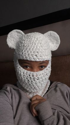 a person wearing a white knitted bear mask