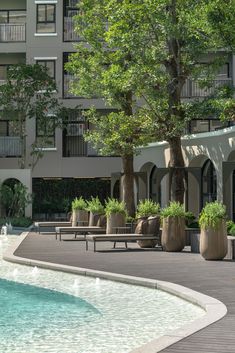 an outdoor swimming pool with lounge chairs and trees