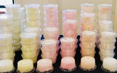 many candles are lined up in rows on a black tablecloth with white and pink ones