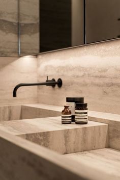 a bathroom sink with two jars on the counter