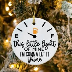 a white ornament hanging from a christmas tree that says,'this little light of mine i'm gonna let it shine