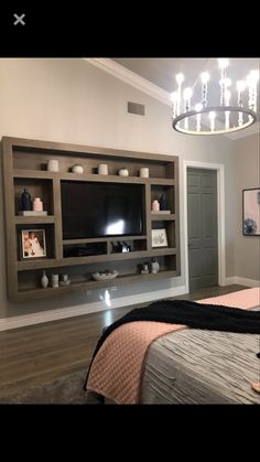 a bedroom with a bed, television and chandelier