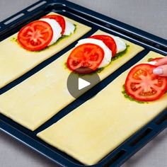 someone is making homemade pizzas with tomatoes and cheese