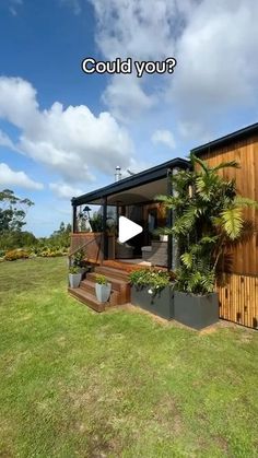 a small house sitting on top of a lush green field next to a wooden fence