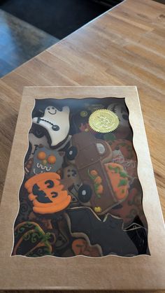 a wooden table topped with lots of halloween themed cookies and candies on top of it