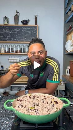 a man sitting in front of a large green pan filled with rice and raisins