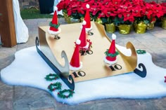 a wooden sleigh with santa hats on it and christmas decorations around the top