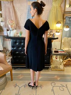 "Vintage 1950's black cotton dress with silk chiffon pleated cross-over detail at bodice with satin bow and dramatic sash - Major Marvelous Mrs. Maisel vibes! Fit: Small Bust: up to 36\" Waist: up to 30\" Hips: 39\" Length: 42\" Condition: Excellent Vintage Condition. All sales are final. Thank you for shopping small and sustainable." Classic Party Dress With Pleated Back, Chic Fitted Vintage Dress With V-neck, Chic Fitted Vintage V-neck Dress, Chic Vintage Fitted Dress With V-neck, Fitted 1950s Style Evening Dress, Vintage V-neck Cocktail Dress, Chic Fitted Vintage Dress For Cocktail, Chic Fitted Vintage Cocktail Dress, Chic Fitted Vintage Dress For Formal Occasions