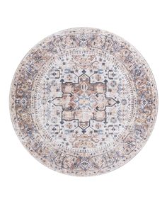 a round rug with an intricate design on the center and sides, in beige tones