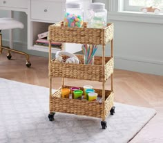 a wicker cart with three baskets on it in a room next to a rug