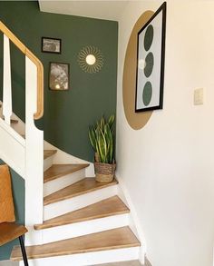 there is a potted plant sitting on the top of some stairs in this house