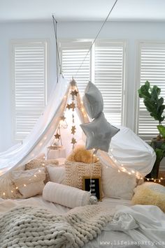 a bed with white sheets and lights on it