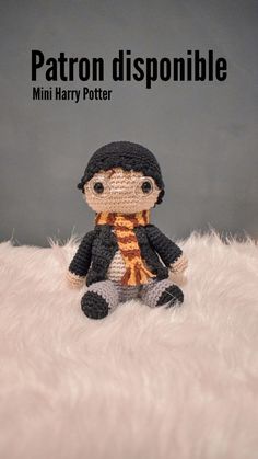 a crocheted doll sitting on top of a white fur covered floor with the caption patron disponible mini harry potter