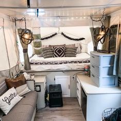 the interior of a camper with white walls and wood flooring, including an overhead bed