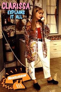 a woman standing in a kitchen talking on a cell phone and holding a chain to her ear