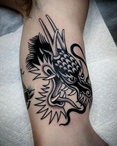 a black and white dragon tattoo on the arm