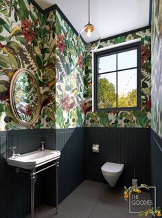 a bathroom with floral wallpaper and green walls