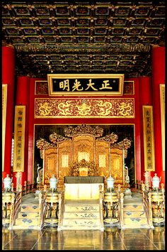 an ornate chinese shrine with gold and red decorations on the walls, pillars and columns