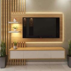 a tv mounted on the wall in a living room with potted plants next to it