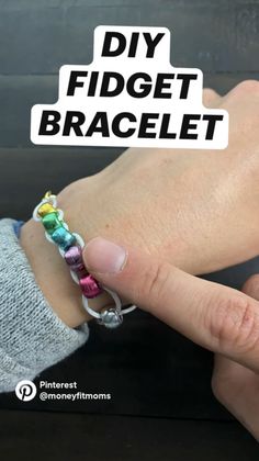 a person is holding onto a bracelet that has been made out of different colored beads