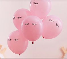 pink balloons with eyes and eyelashes on them