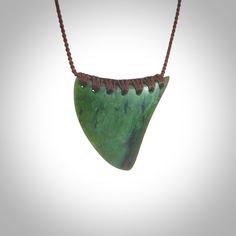 a green necklace with brown beads and a large piece of jewelry hanging from it's side