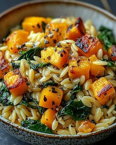 a bowl filled with pasta and vegetables on top of a table