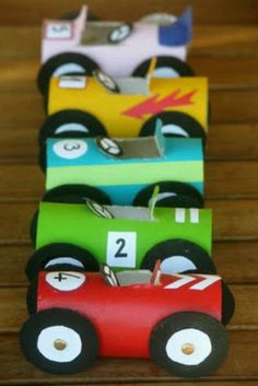 some paper cars sitting on top of a wooden table