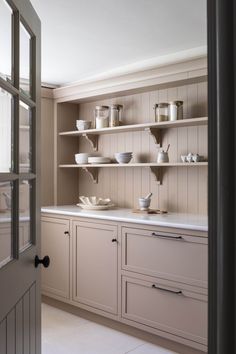 the kitchen is clean and ready to be used for cooking or baking, with dishes on the shelves