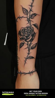 a black rose tattoo on the arm with barbed wire around it's edges and leaves