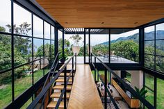 the inside of a modern house with glass walls and stairs leading up to an upper level