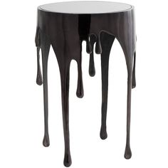 a black and white side table with dripping chocolate syrups on the top, against a white background