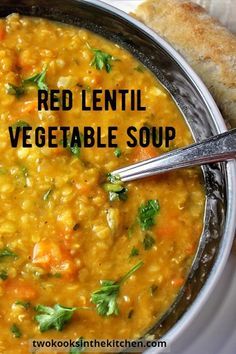 a bowl of red lentil vegetable soup with bread on the side