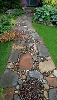 a walkway made out of rocks and stones in front of a purple house with green grass