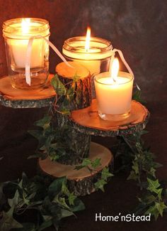 three lit candles sitting on top of wooden slices