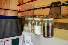 three jars filled with liquid sitting on top of a counter next to a light fixture