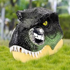 an inflatable alligator head is sitting on the grass with it's mouth open