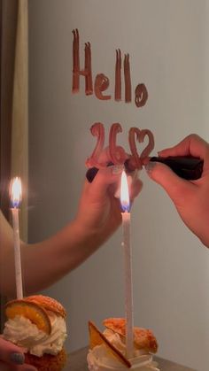 two people lighting candles on a cake with the word hello 205 written on it in front of them