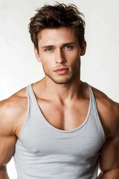 a young man posing for the camera with his hands on his hips and wearing a tank top