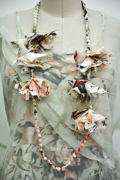 a woman's dress with flowers and beads on the front, attached to a mannequin