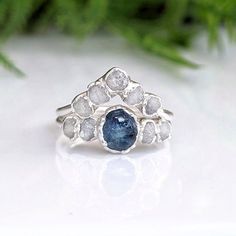 a blue and white diamond ring sitting on top of a table